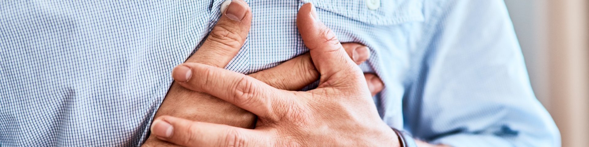 Chest pains are never a good sign. Shot of a unrecognizable man holding his chest in discomfort due to pain at home during the day.